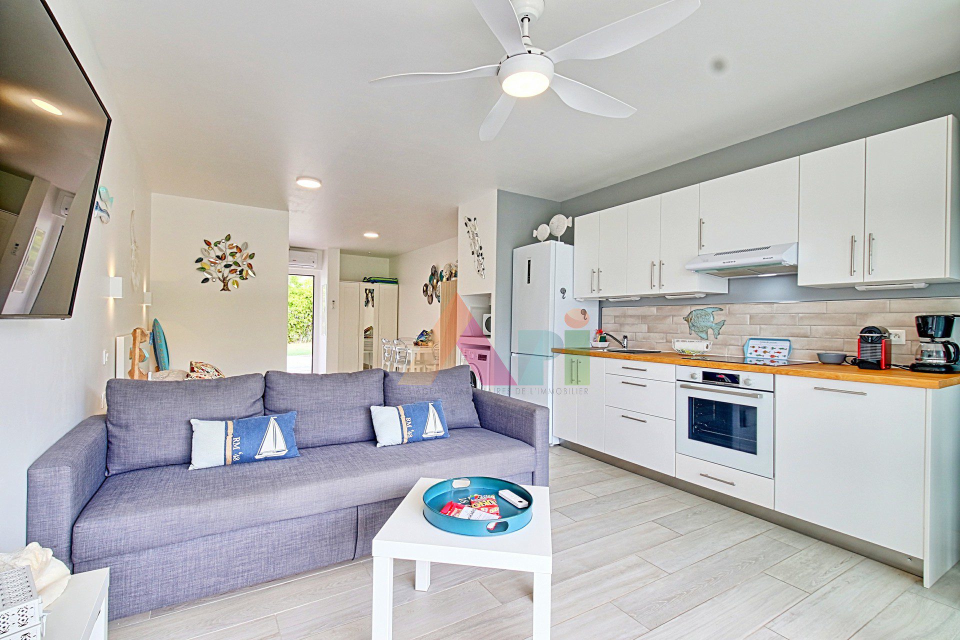 Apartment 806: grey sofa, white kitchen and coastal decor